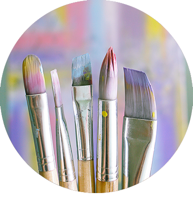 Brush tips that have been dipped in pastel colors in front of painting