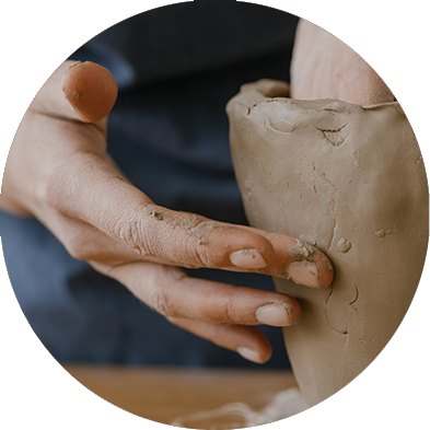 Hands building a pot and holding clay